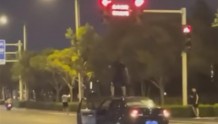 网传郑州一男子坐车顶开车还闯红灯，交警：正调查